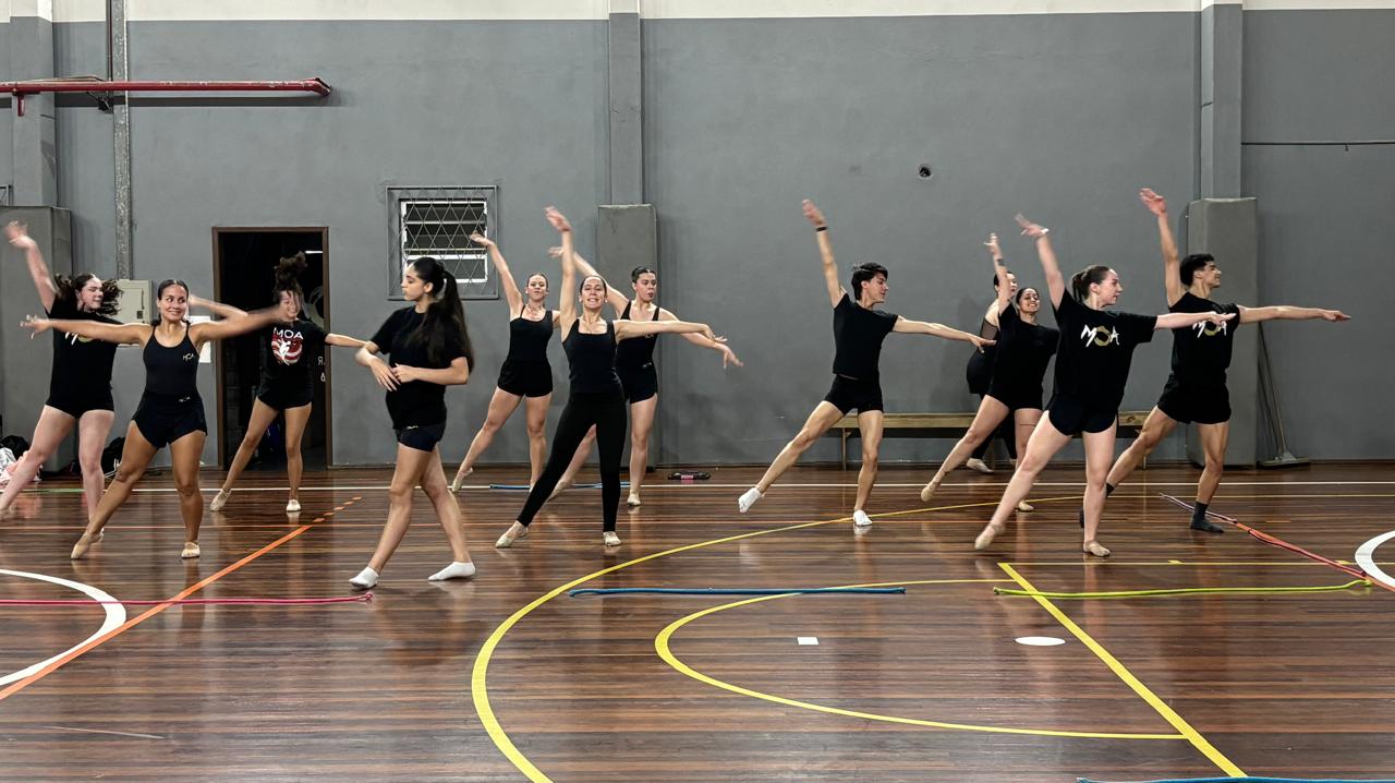 Grupo de bailarinos ensaia em um ginásio