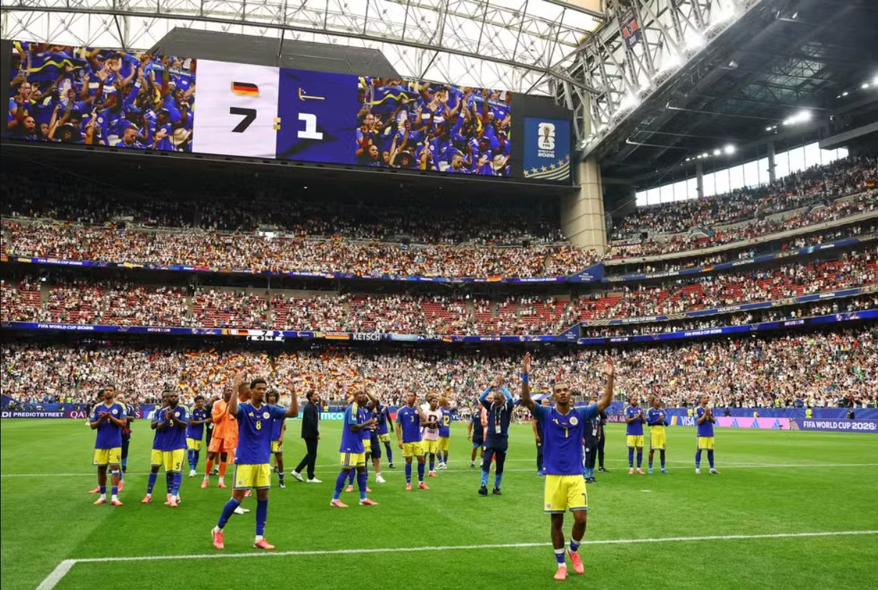 Imagem de estadio lotado com o resultado do jogo em destaque. Logo abaixo, o time vencedor comemora.