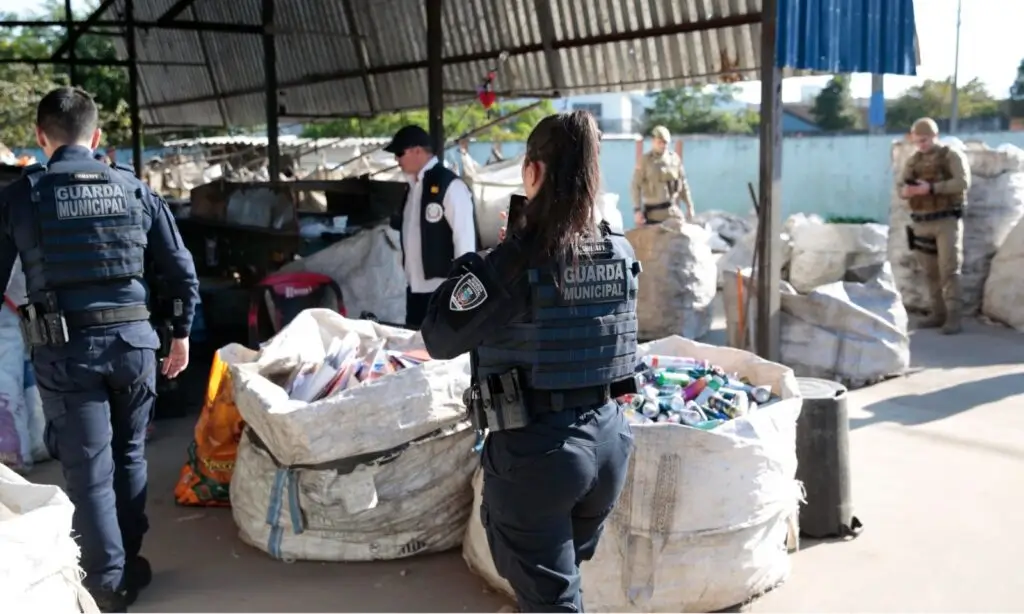 Policiais fiscalizando produtos em um comércio de sucata.